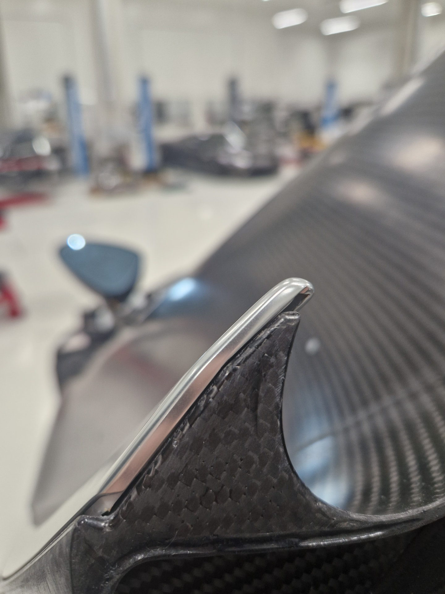 Close-up of a polished trim edge on a carbon fibre panel