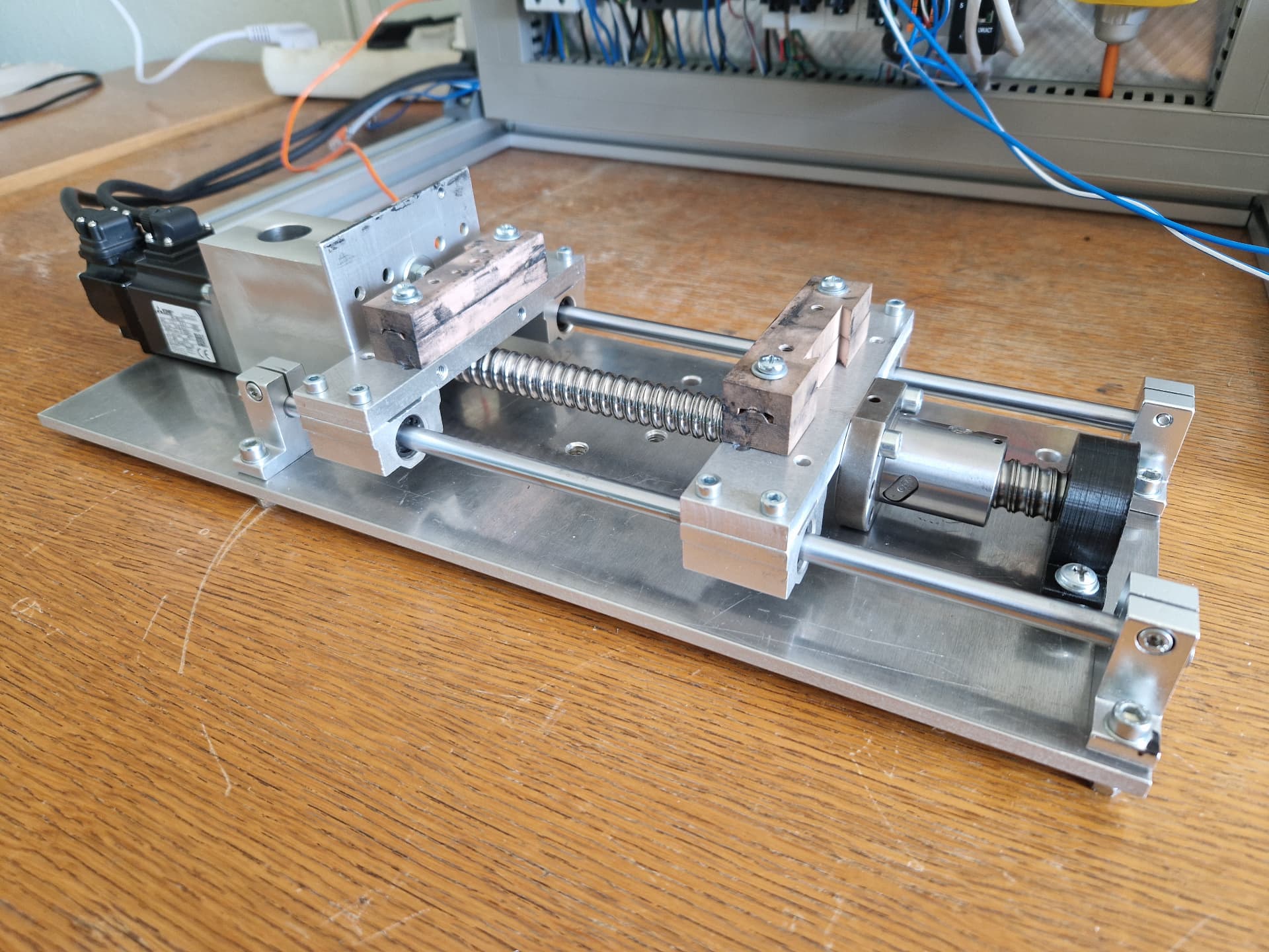 Servo-driven linear ball screw axis with machined clamping fixtures